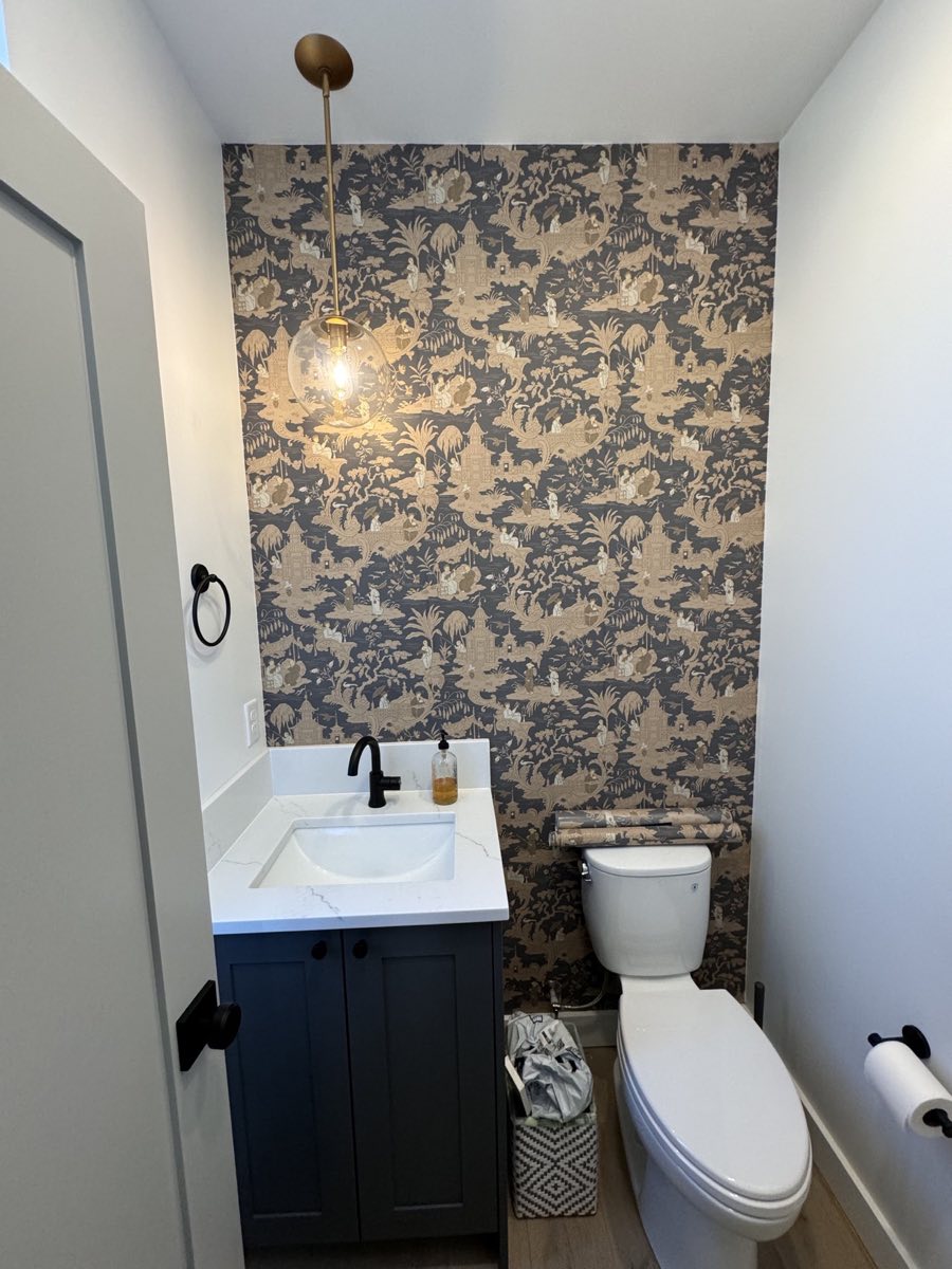 Patterned blue and ivory wallpaper installed in a finished powder room