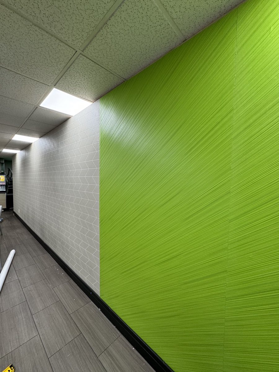 Bright green textured commercial wallcovering beside geometric tile