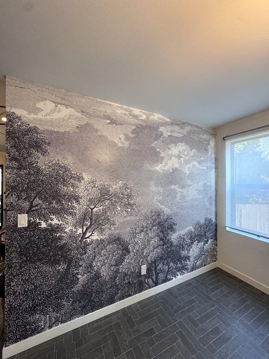 Black and white landscape mural installed across a bright interior wall