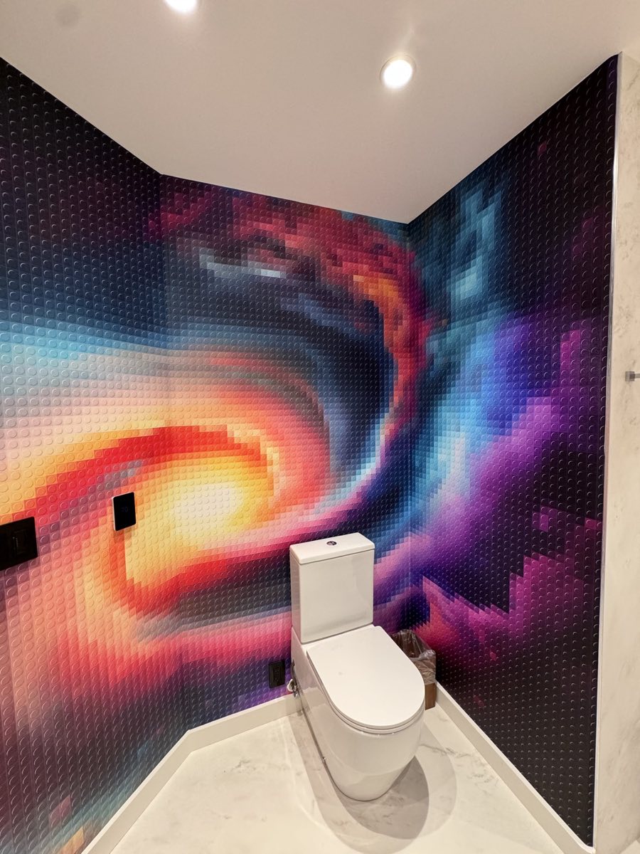 Colorful pixel-style mural wrapping a compact powder room