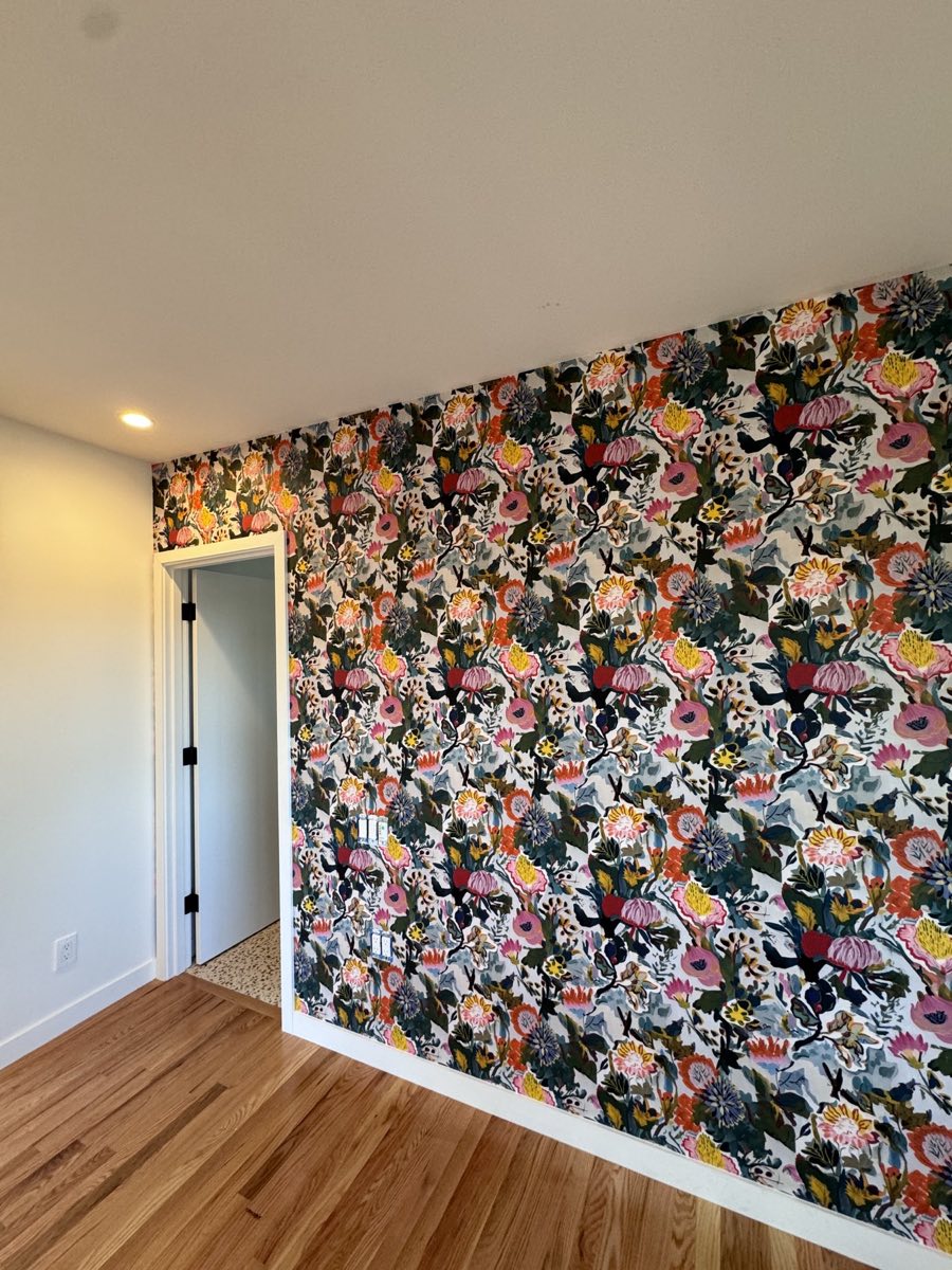Colorful floral wallpaper installed as a full feature wall around a doorway