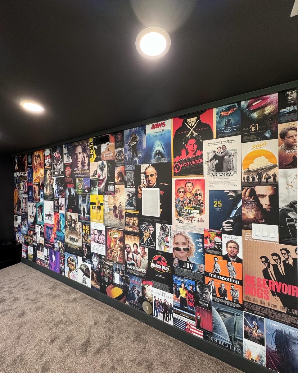 Angled view of a cinema poster wall wrapping a media room